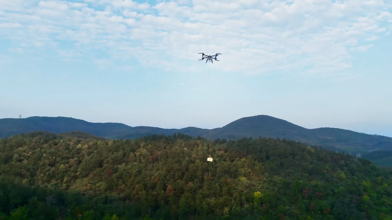 Drone EFT em operação industrial transportando carga sobre o relevo
